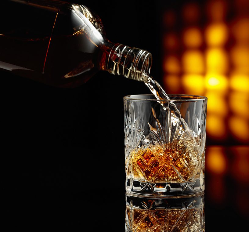 Whiskey being poured with warm lighting