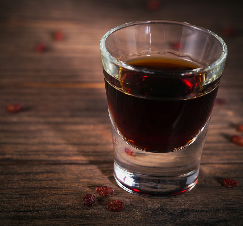 Shot glass with dark liquid on table