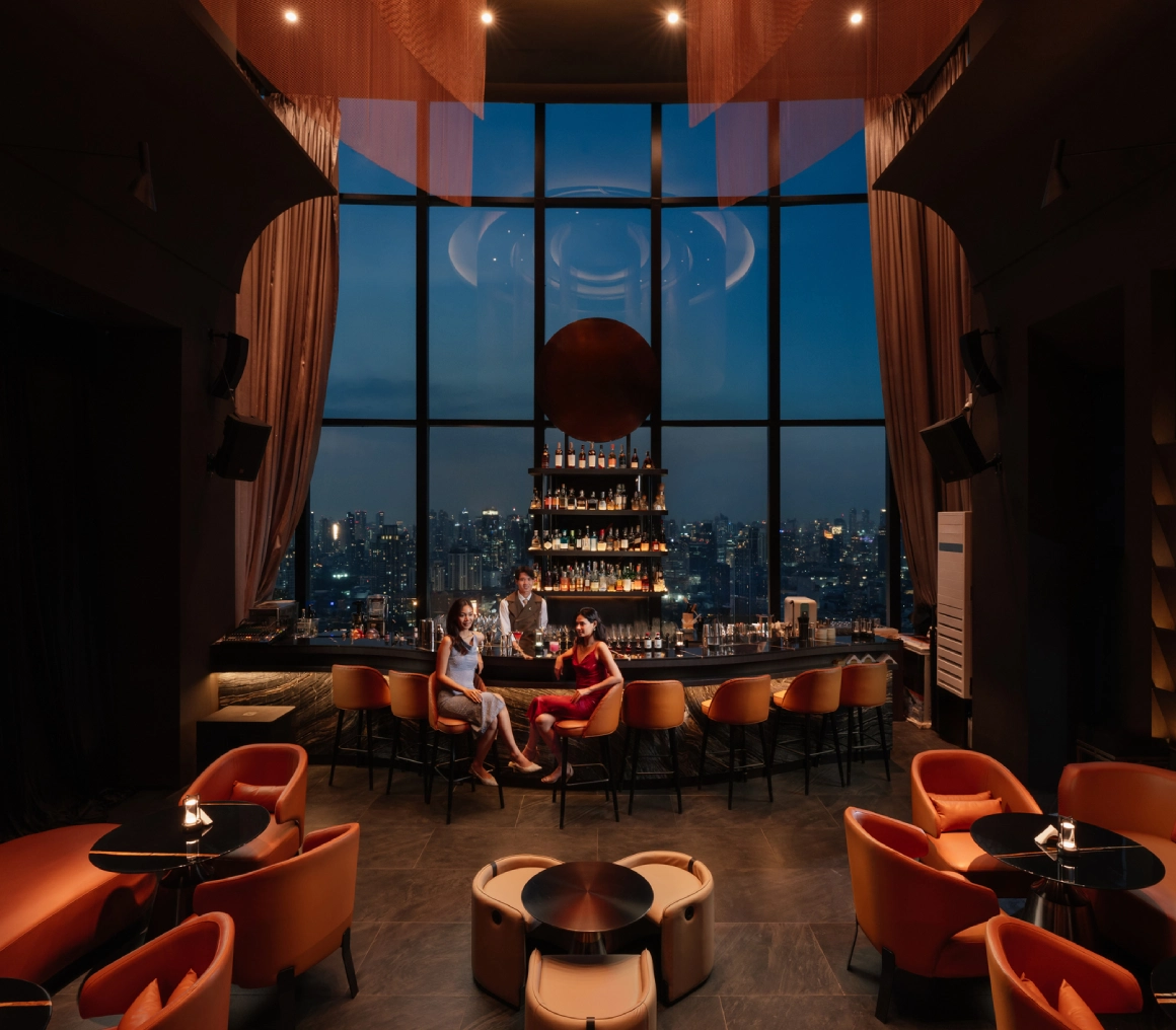 Elegant lounge with a striking city view through large windows at dusk.