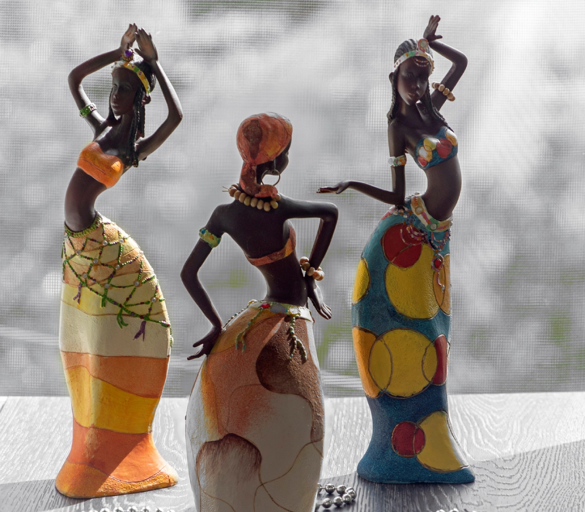 Three colorful African tribal figurines with distinct patterns and poses.