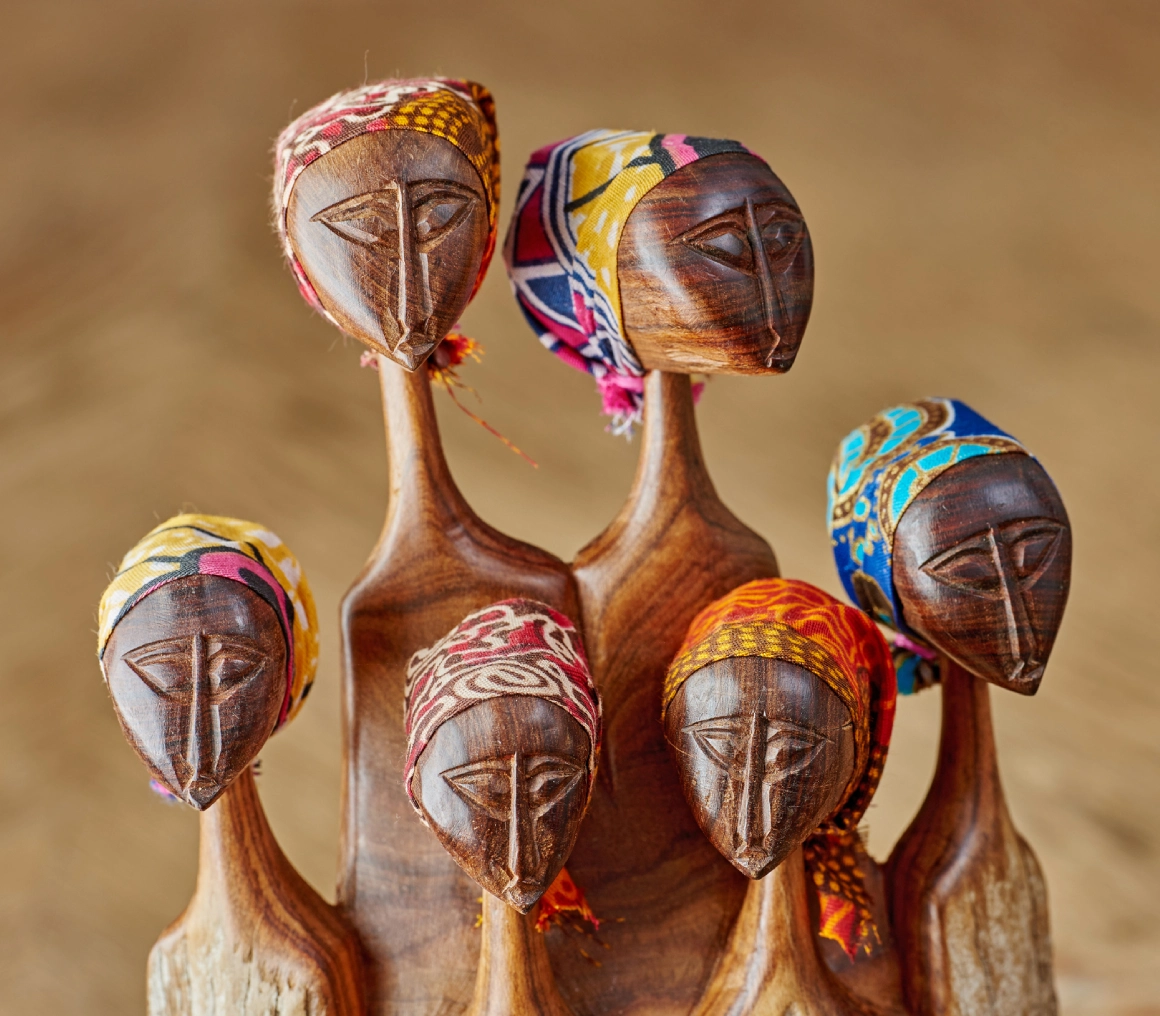 Artistic wooden sculptures with colorful painted faces and headdresses.