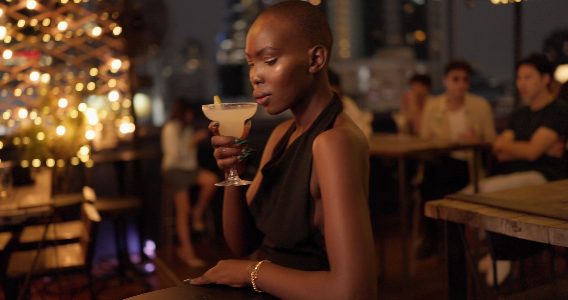 Woman enjoying a drink in a dimly lit bar.